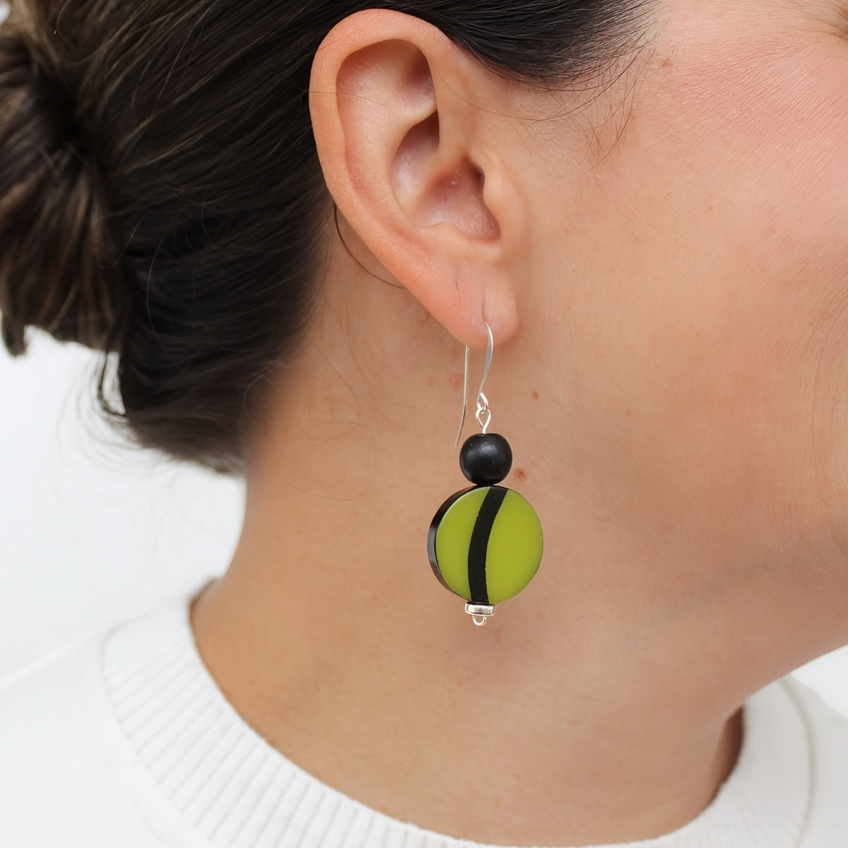 Green and black resin earrings shown on model