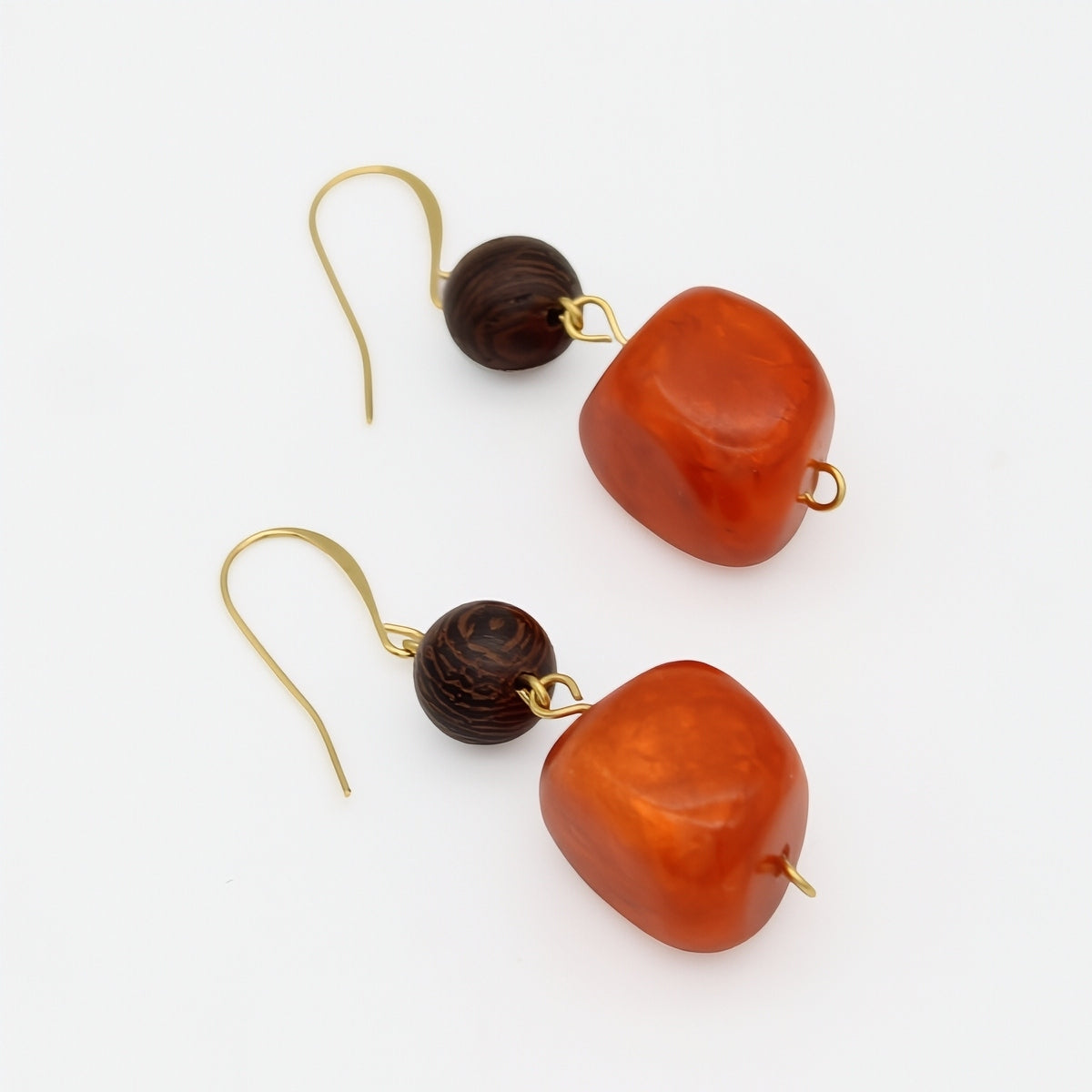 Orange resin and wood statement earrings angled product view