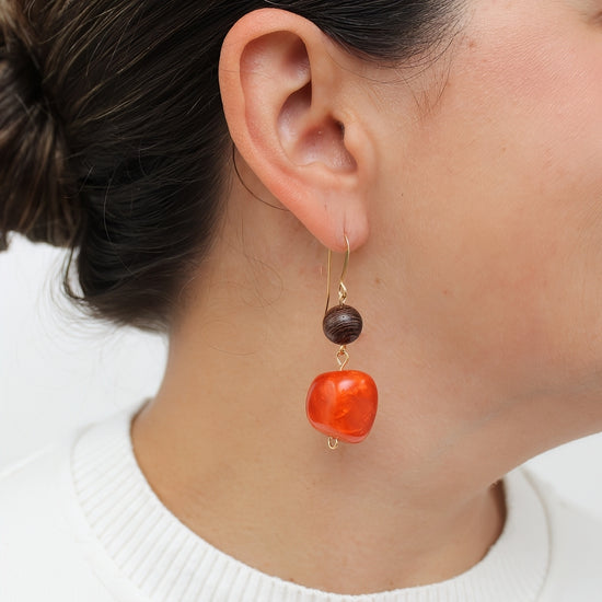 Orange resin and wood drop earrings shown on model