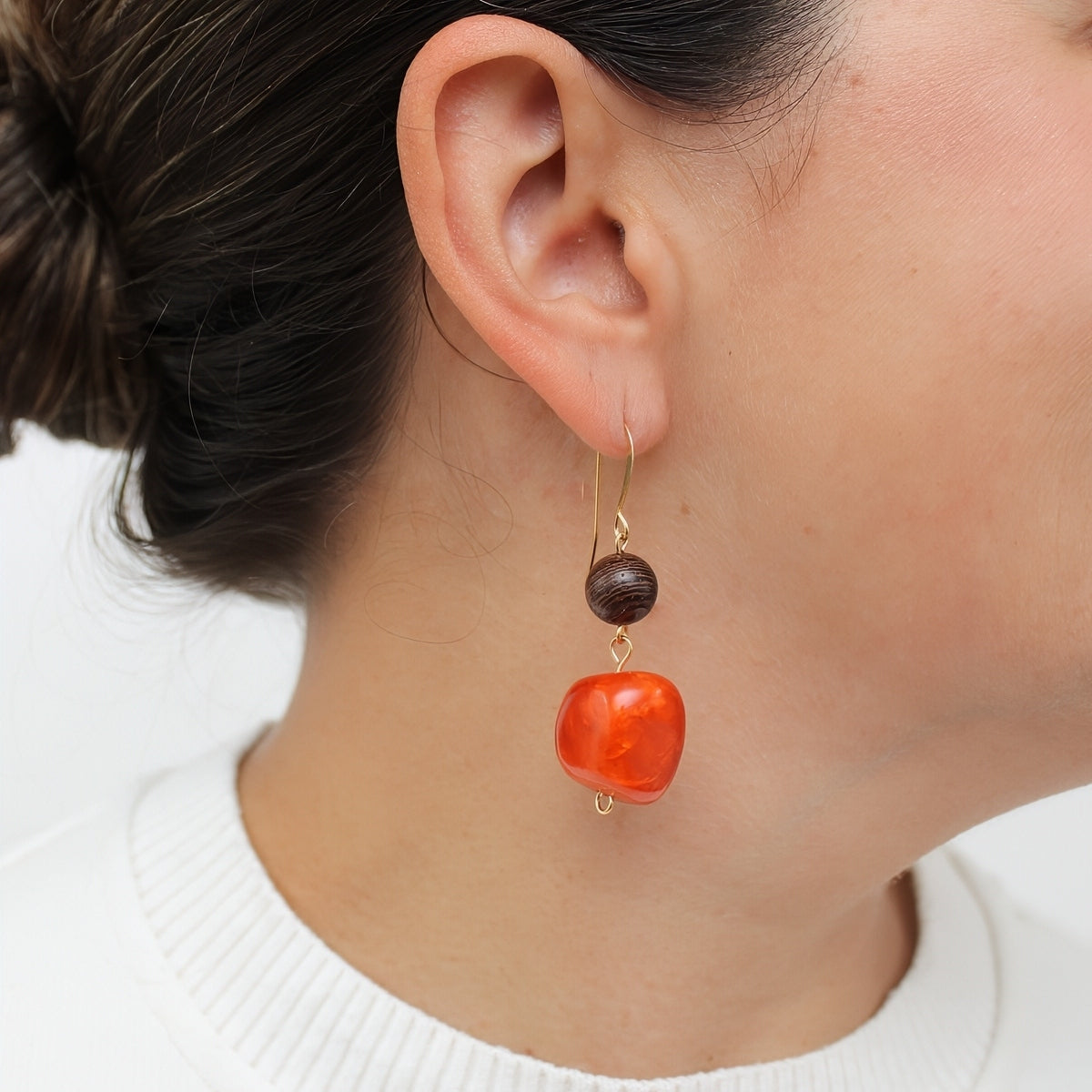 Orange resin and wood drop earrings shown on model