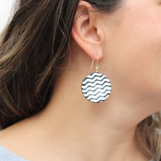 Black and white resin disc earrings shown on model