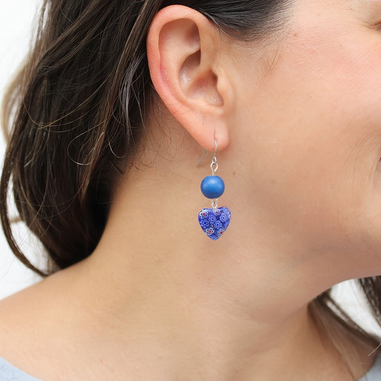Blue floral heart earrings shown on model