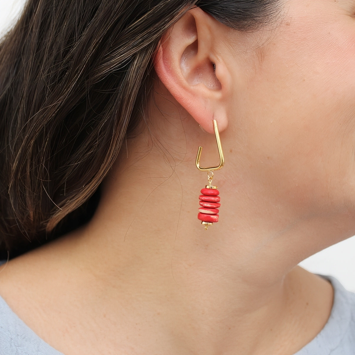 Red statement earrings shown on model