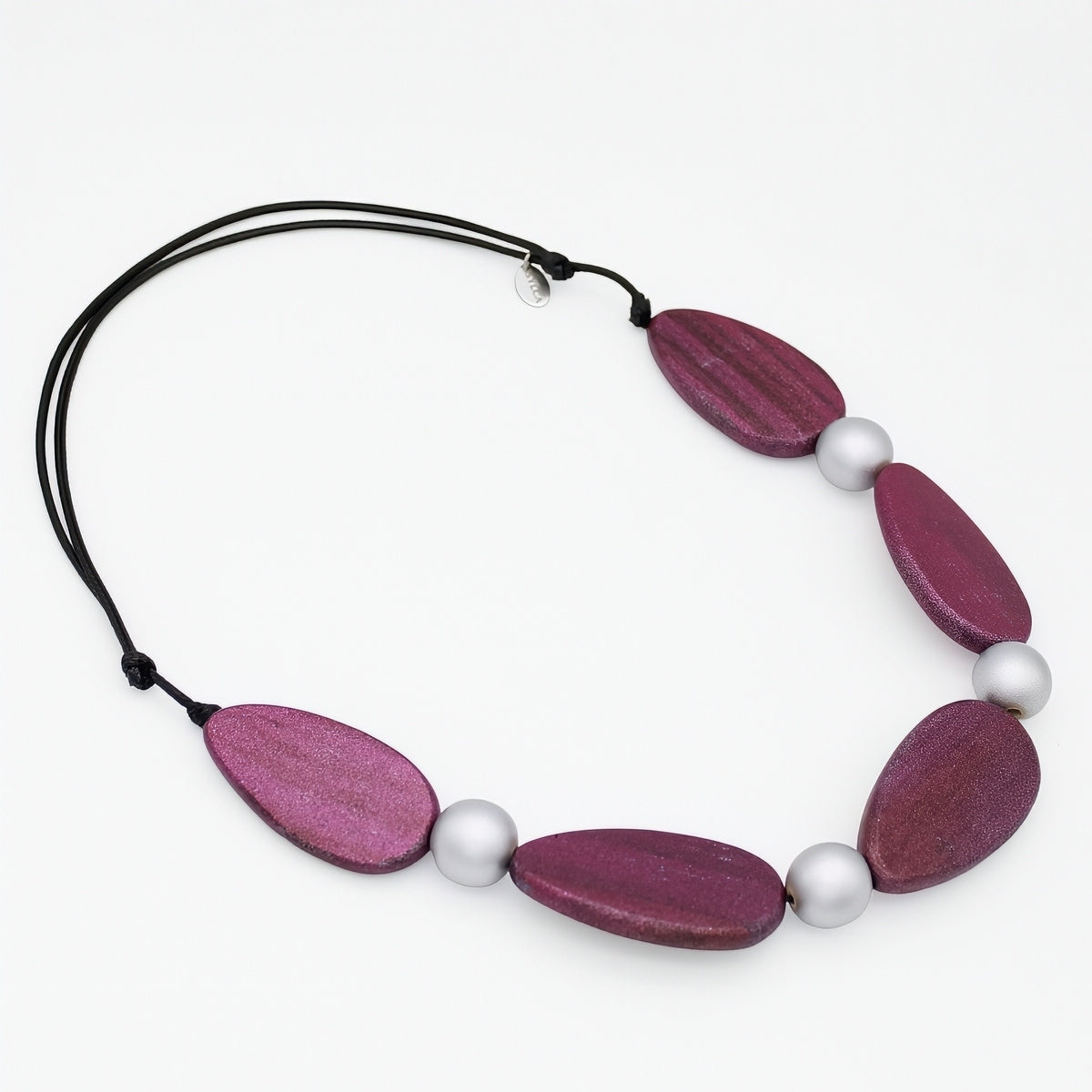 Necklace with purple wooden beads and white pearls on a white background