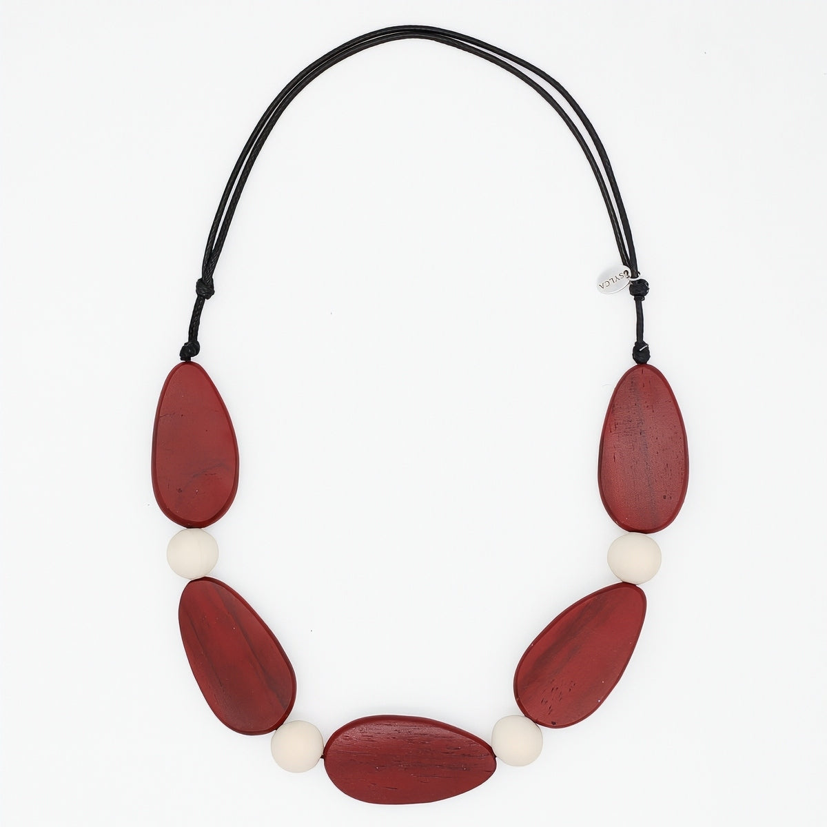 Necklace with red and white beads on a black cord against a white background