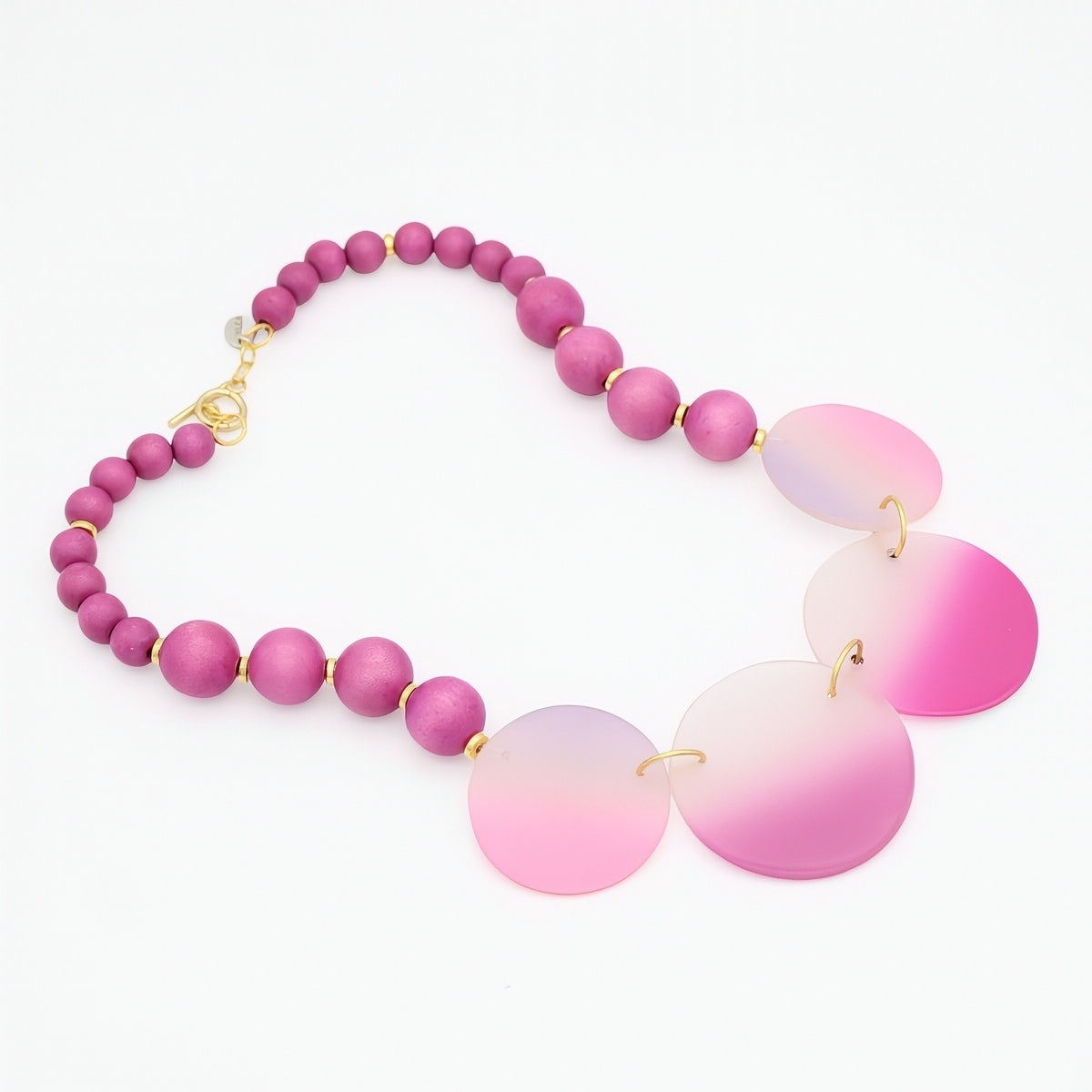 Necklace with pink beads and gradient pink pendants on a white background