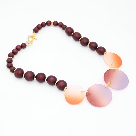 Necklace with wooden beads and gradient glass pendants on a white background
