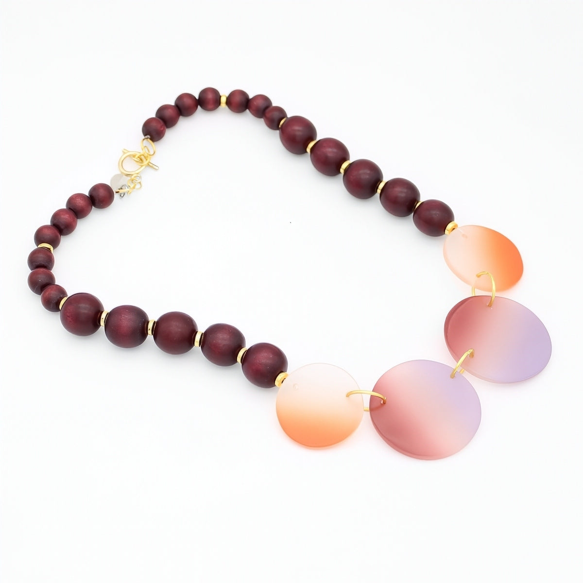 Necklace with wooden beads and gradient glass pendants on a white background