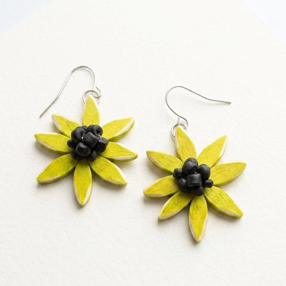 chartreuse flower-shaped earrings with black centers on a white background