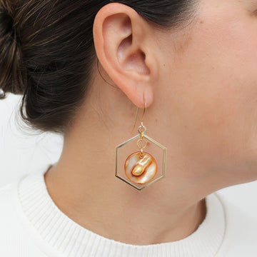 Gold hexagon statement earrings with resin accents shown on model