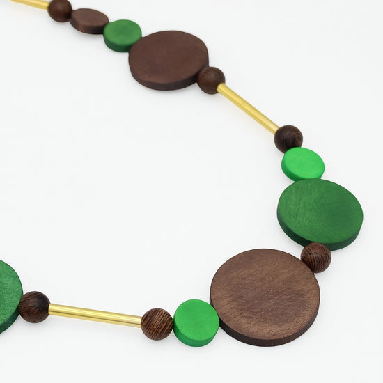 Close up of green and brown wood circle necklace with gold accents
