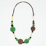 Green and brown wood circle statement necklace with gold accents on white background
