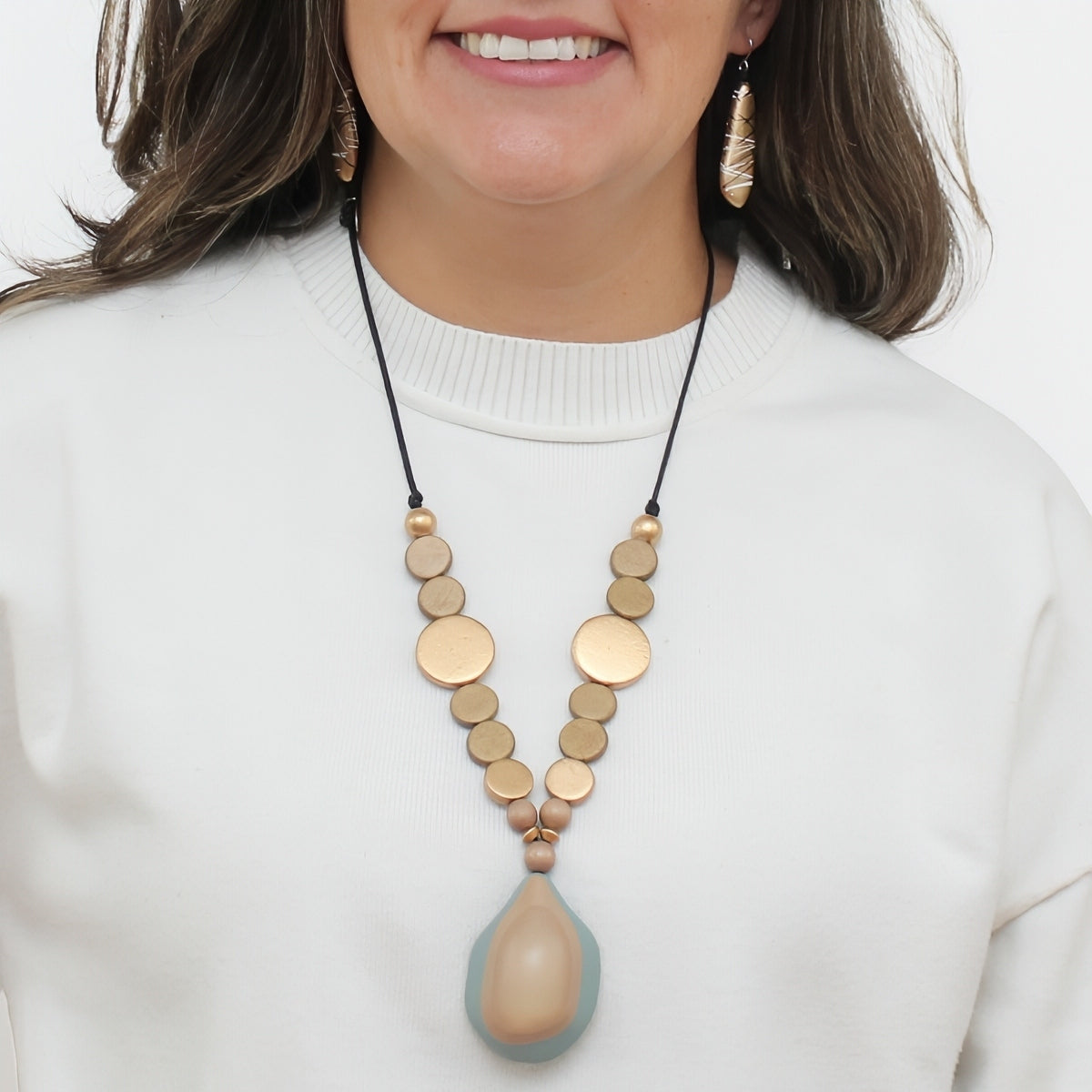 Taupe and gold wood statement necklace with resin pendant worn on model