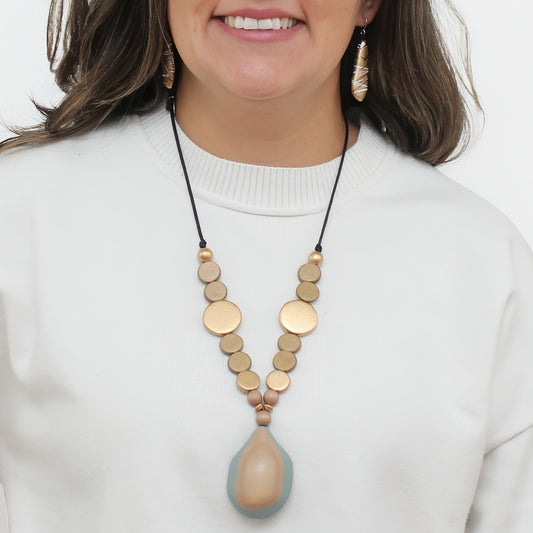 Taupe and gold wood statement necklace with resin pendant worn on model