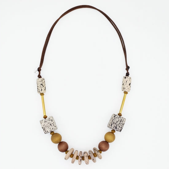 Natural wood statement necklace with speckled cream beads and gold accents on white background