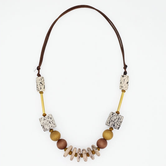 Natural wood statement necklace with speckled cream beads and gold accents on white background