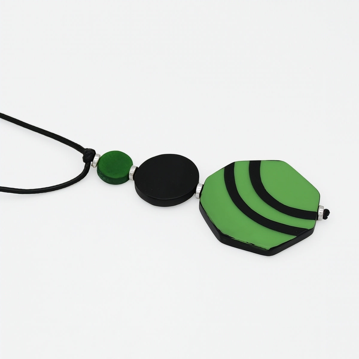 Close up of green and black geometric resin and wood pendant