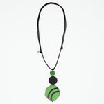 Green and black resin and wood pendant necklace on white background