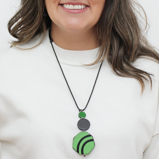 Green and black resin and wood pendant statement necklace worn on model