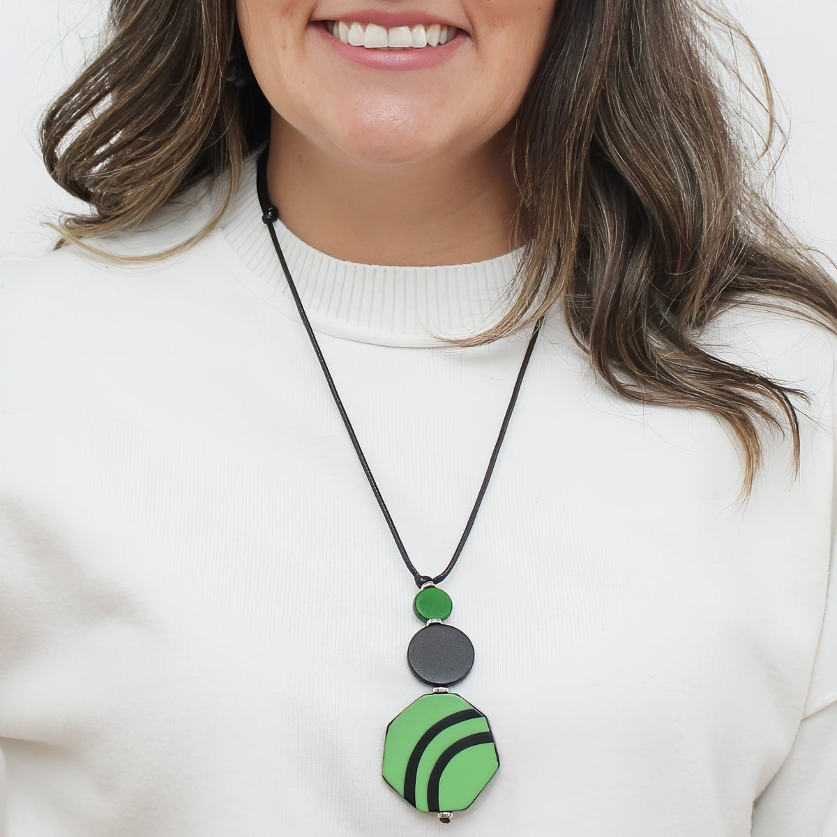 Green and black resin and wood pendant statement necklace worn on model
