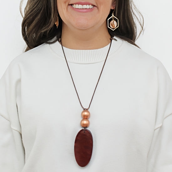 Brown resin pendant necklace shown on model